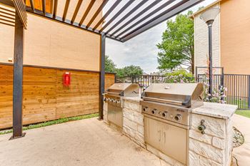 Outdoor grilling area with covered pergola and stone countertop